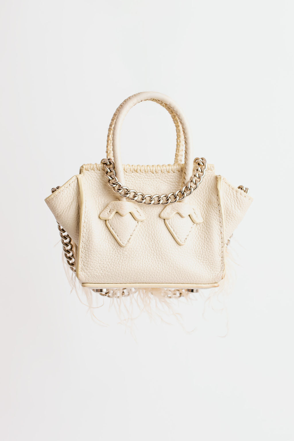 La Bebe en blanco roto con plumas